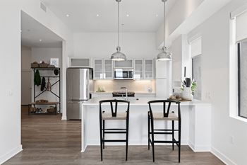 a kitchen with a large island with two stools